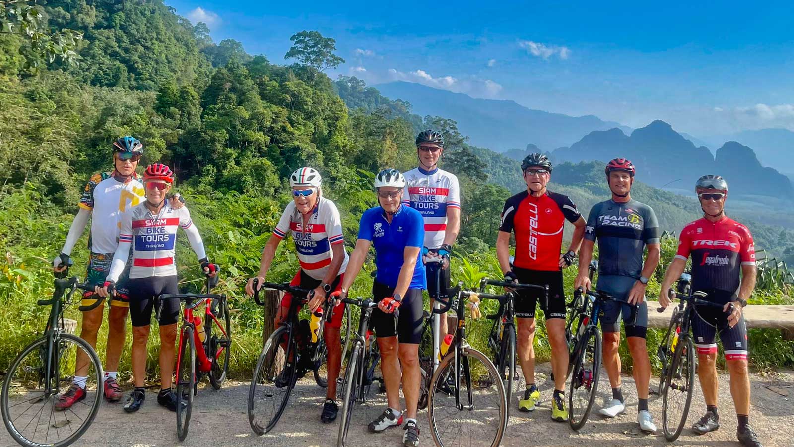 Cyclists posing in front of scenic Thai landscape
