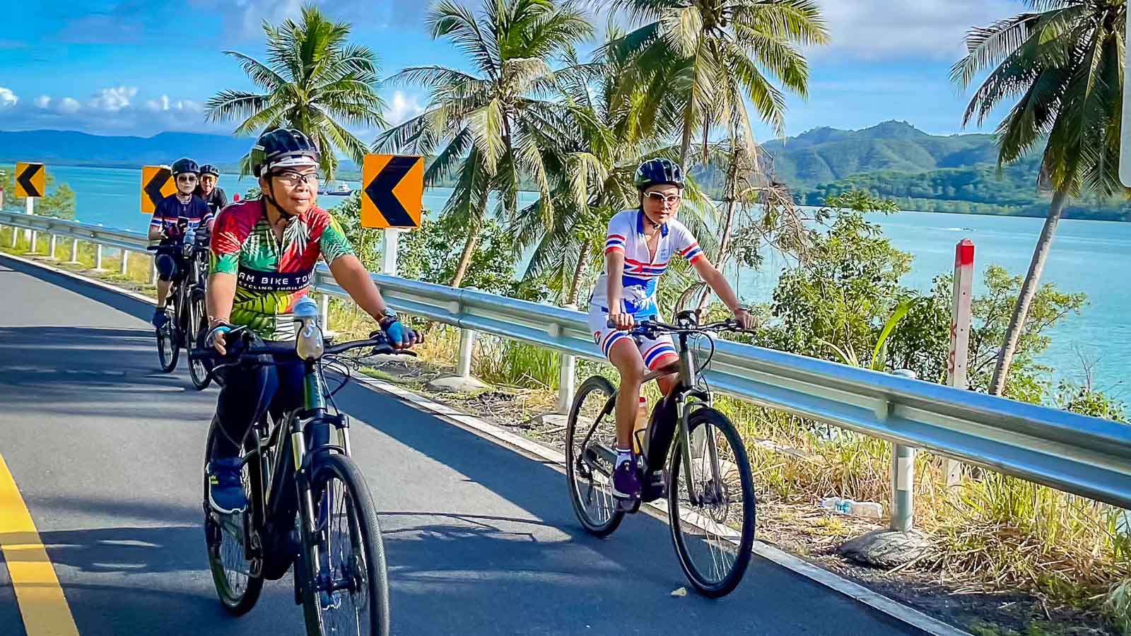 Cyclists riding along coast in Phuket, Thailand
