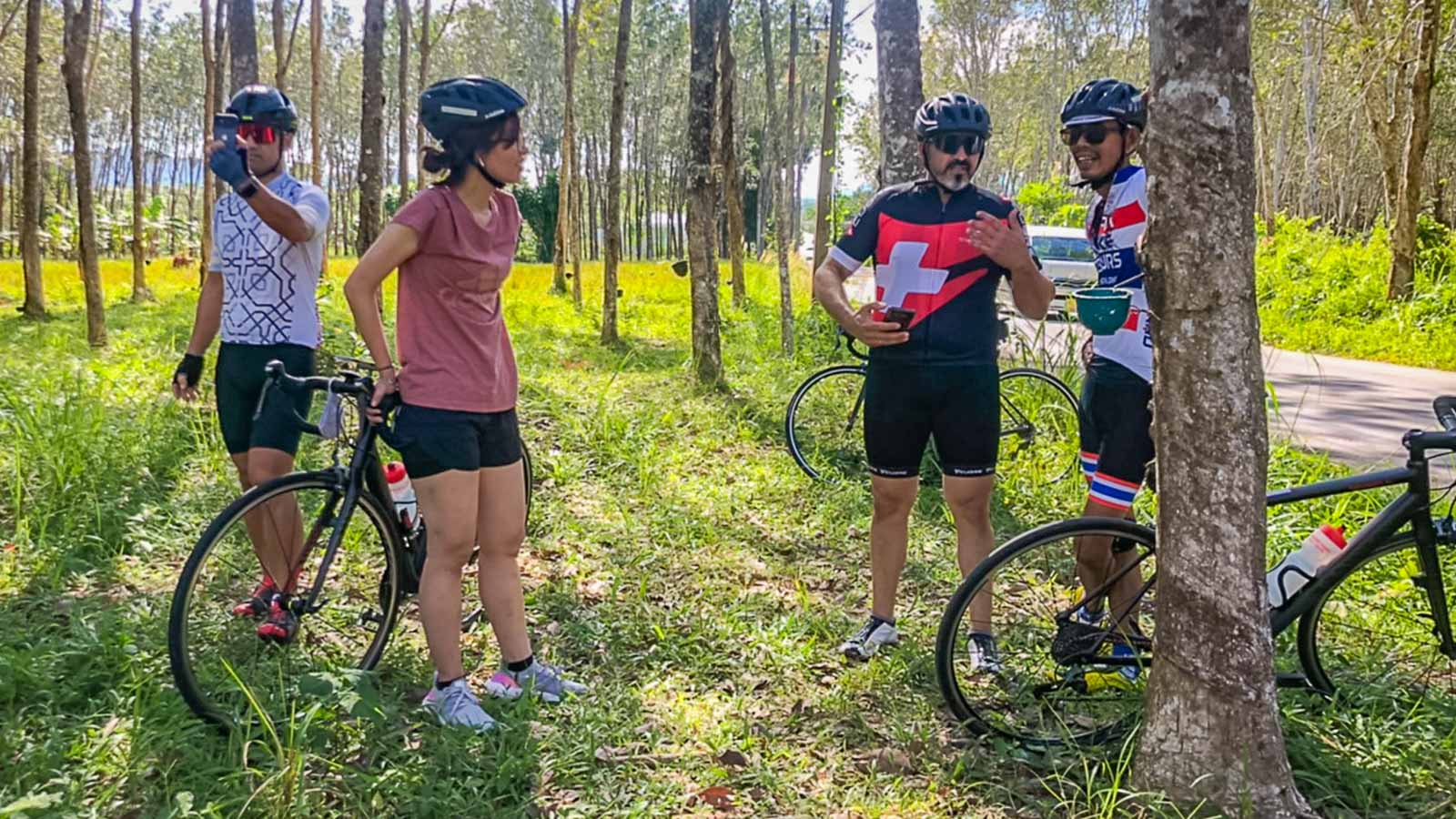 Cyclists taking break in front of rubber trees in Thailand